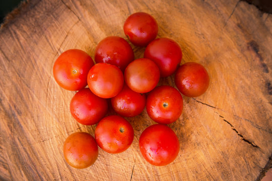 Tomates cherry jugosos sobre una tabla de madera.