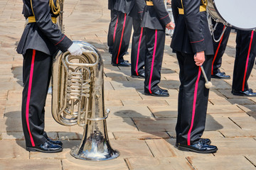Military musicians at a performance with a tuba and a drum in their hands