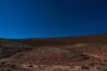 Fototapeta na wymiar Amazing striped red mountains on a moon night