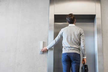 Businessman waiting for elevator in office