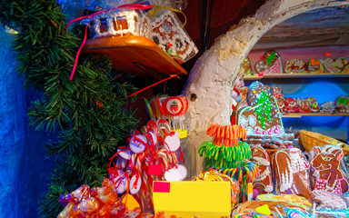Candy canes and gingerbread hearts and houses displayed on a traditional European Christmas market...