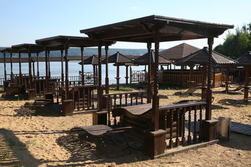 Wooden sunbeds and umbrellas on a deserted beach in low season.