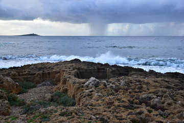 Temporale che si avvicina alla costa . in primo piano una vecchia cava di pietra arenaria . Palermo, località Sferracavallo- Sicilia