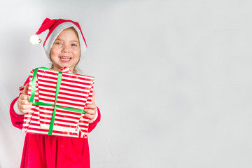 Happy little smiling girl with christmas gift boxes