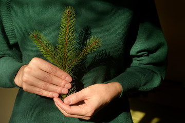 Woman is holding pine tree branch