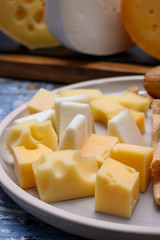 Tasty snacks, cheese blocks from Dutch yellow gouda and white goat hard cheeses and French holes cheese emmentaler