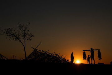 Fototapeta na wymiar farmers returning to their home at sunset