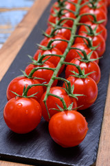 Small ripe red sweet cherry tomatoes on twig