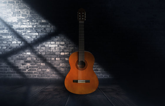 Guitar in a dark room with brick walls, wooden floor. Abstract light. Dark empty scene with a musical instrument. © MiaStendal