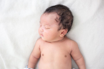 Newborn infant boy sleep on white blanket