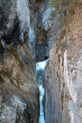 Fototapeta na wymiar Cascade en montagne au milieu de deux parois montagneuses