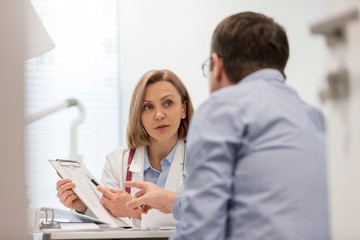 Doctor giving patient prescription in clinic