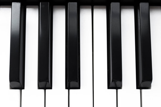 Close up photo of keyboard of piano or electronic digital  midi synthesizer. View from above, top view. Musical classic instrument background, music player concept. Black and white key. Vintage style.
