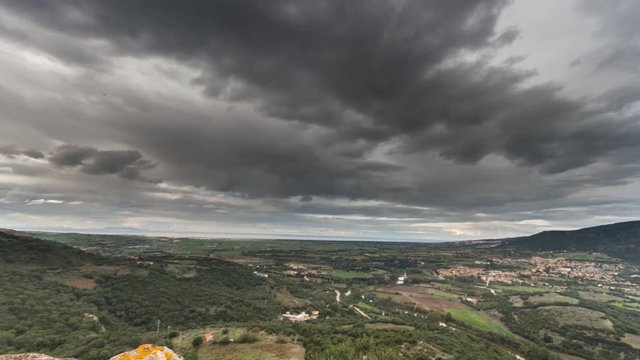 time lapse of the castle torre dei doria chiaramonti santa maria goghinas in Sardinia with the panorama of the Mediterranean maquis with heavy clouds