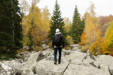 Obraz premium Teenage Caucasian man on a volcanic stones in a mountain. Selective focus