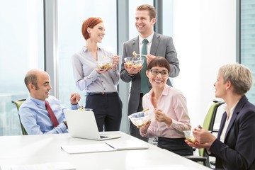 Business poeple eating lunch together during break in office