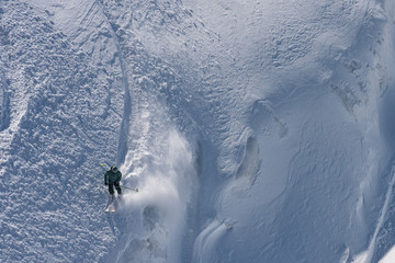 Skier skiing high mountains in fresh powder snow, Mt. Titlis, Switzerland.