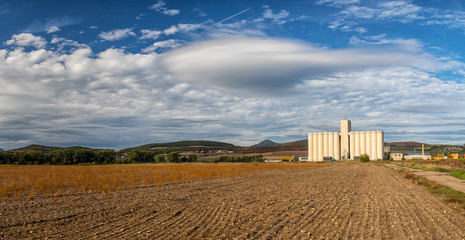 landscape with field and silo, hills and blue sky with white clouds in background, Polepy, Czech republic