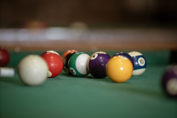Sports game of billiards on a green cloth. Billiard balls with numbers on a pool table. Billiards team sport.