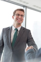 Naklejka premium Businesman shaking hands with business partner in office