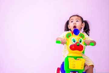 an Asian gir Kindergarten girl playing tricycle