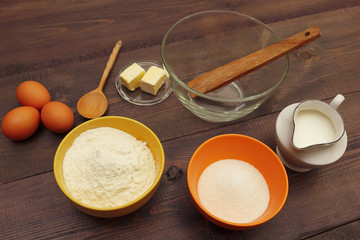 Necessary ingredients for making dough on a wooden table.