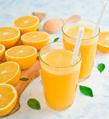 Glass of freshly squeezed orange juice and slices of orange fruit isolated on white background