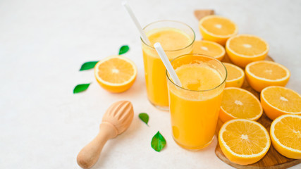 Glass of freshly squeezed orange juice and slices of orange fruit isolated on white background
