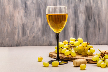 Wine glass, fresh grapes and corks on wooden chopping board. Wine bar, winery, wine tasting...
