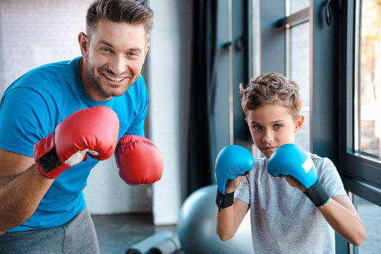 Happy Father And Cute Son In Boxing Gloves Working Out In Gym