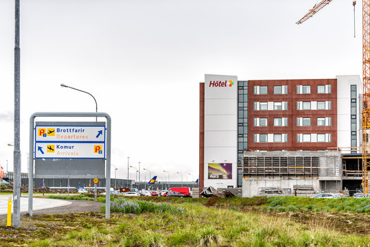 Keflavik, Iceland - June 14, 2018: Hotel at Airport in Scandinavian city by Reykjavik with information direction signs, modern building construction, crane, parking lot, departures and arrivals