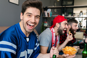 Photo of guys screaming and drinking beer while watching sports match