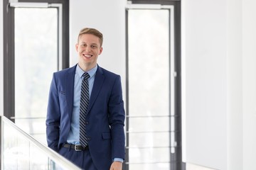 Young attractive businessman standing in office