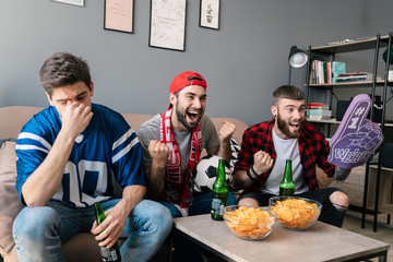 Photo of guys eating chips and drinking beer while watching sports match