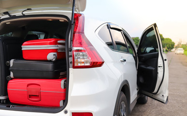 Closeup of rear or back side of white car carrying luggage, suitcases with natural background....