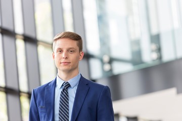 Fototapeta premium Young attractive businessman standing in office