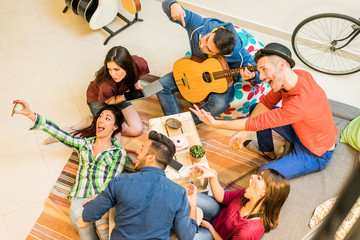 Trendy friends having fun in hostel at party night taking selfie - Happy travel people enjoying...