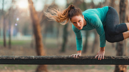 Woman Jumping Over the Wooden Huddles