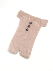 Baby clothes for newborn in brown, beige colors on white wool background. Body for newborn. Top view, flat lay.