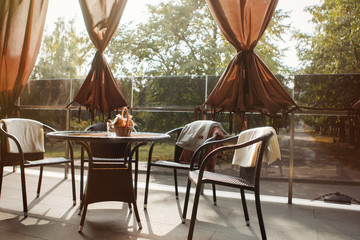 Two rattan cafe chairs against brick wall