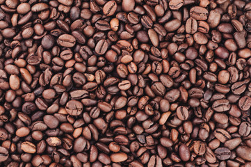 Many scattered roasted coffee beans. Background. Close-up