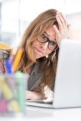 Stressed businesswoman sitting in her desk in office