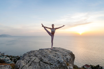 girl practices yoga at sunrise