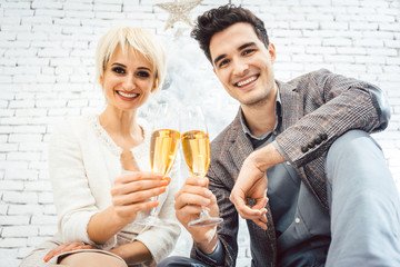 Couple clinking with sparkling wine for Christmas