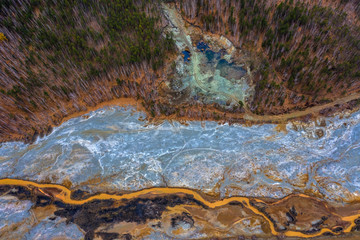 Aerial view drone flying forward over polluted river with destroyed ecosystem and copper tailing dump poisoning ground and water air emissions from industry environmental disaster in South Ural.