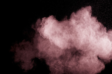 Abstract pink dust explosion on black background.  Freeze motion of pink powder splash.