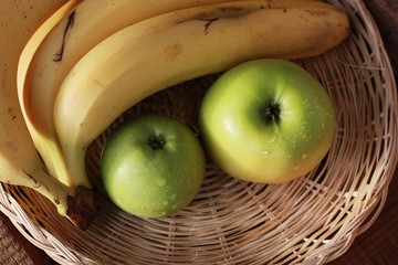 Green apples and bananas on the table