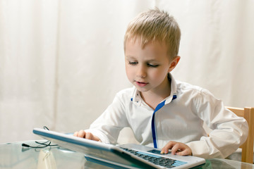 little boy plays on training computer