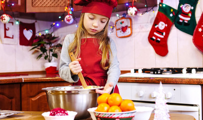 A girl chef mixing a dough in the bowl with a big wooden shoulder silicone