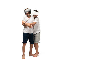 boy hugging smiling brother while using vr headsets together on white background